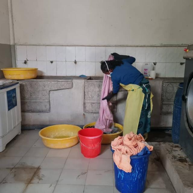 Woman washing bed sheets